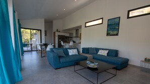 A modern living room with a sofa set, a coffee table, and a dining area with chairs. - Exceptional Villa with Ocean Views in Campomoro, Sleeps 6, Near the Beach (BELVEDERE-CAMPOMORO)