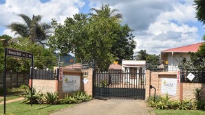 A gated entrance with a sign for Siesta B&B, surrounded by greenery and a clear sky. - Siesta B&B (Abaqulusi)