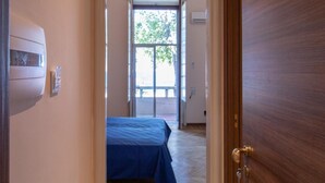 A narrow hallway leading to a bedroom with a bed and a window. - Teatro sullo Stretto (Messina)