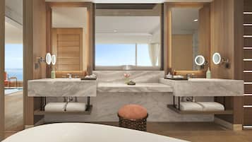 A modern bathroom with two sinks, a large mirror, and a bathtub.