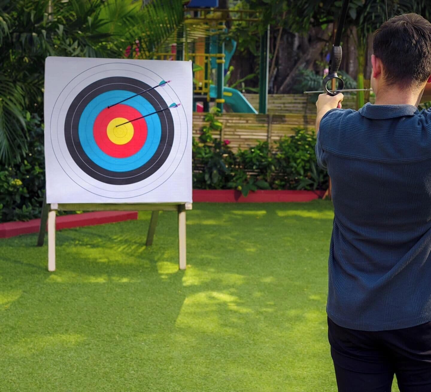 A person aiming an arrow at a target with concentric circles.