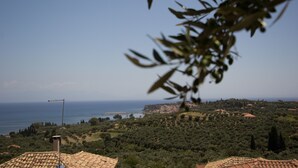 A coastal landscape with terracotta-roofed buildings, dense greenery, and a clear view of the sea. - DIMITRA (no 4)... vacation villa in Koroni of Messinia with sea view!!! (Koroni)