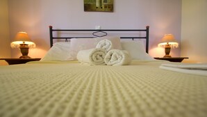 A neatly made bed with rolled towels, a heart-shaped decoration on the headboard, and two bedside lamps. - DIMITRA (no 4)... vacation villa in Koroni of Messinia with sea view!!! (Koroni)
