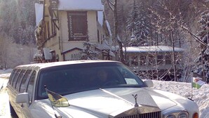 Un Rolls Royce blanco estacionado frente a un edificio con un letrero que dice 'ROMKERHALLE HOTEL RESTAURANT'.