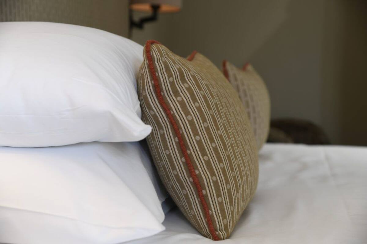 A bed with white and striped pillows.
