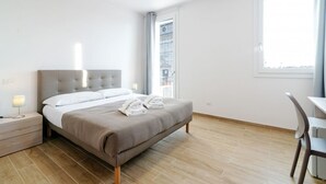 Ein modernes Hotelzimmer mit einem großen Bett, einem Schreibtisch und einem Fenster mit Blick.