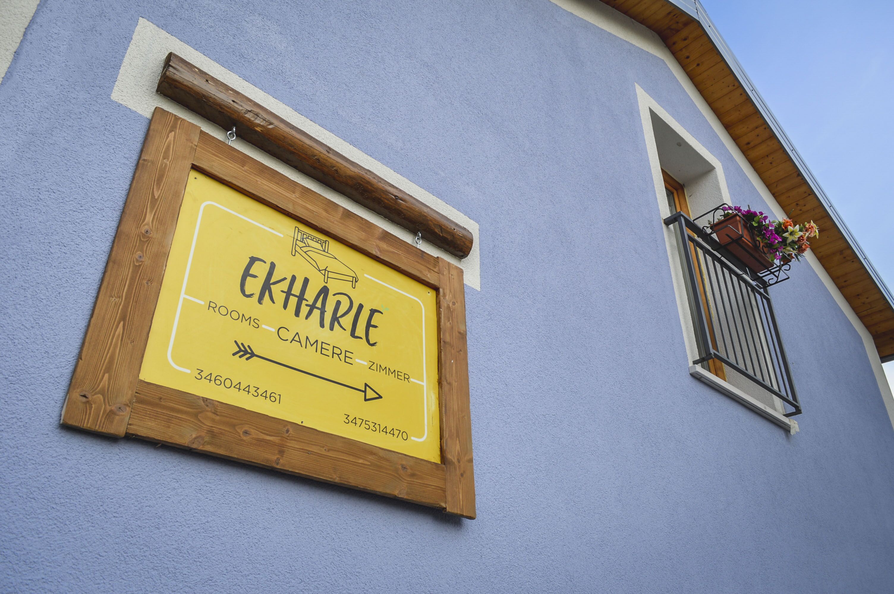 A sign for "Ekhare" indicating rooms and camera rooms with contact numbers.
