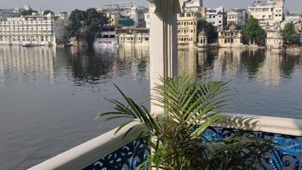 A view of a lake with buildings in the background. - Jheel Hotel and Restaurent (Udaipur)