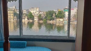 A room with a view of a cityscape through a window. - Jheel Hotel and Restaurent (Udaipur)
