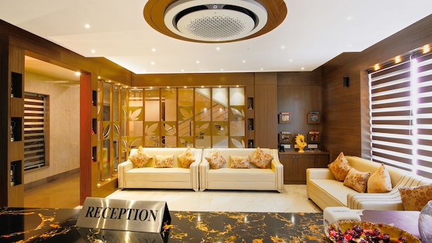 Un área de recepción con dos sofás, un mostrador y una pared decorativa con un diseño geométrico.