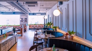 Un restaurante con cabinas, mesas y una zona de bar.