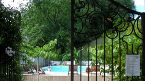 A gated pool area with lounge chairs and a swimming pool.