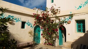 A traditional building with arched doorways and a bench outside. - Dar Lily (Erriadh)