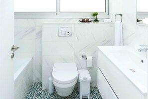 Un baño moderno con inodoro, bidé y lavamanos.