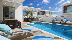 A swimming pool area with lounge chairs and a covered seating area. - SUNDAY - 3bed Villa walking distance to Ayia Napa Center (Ayia Napa)