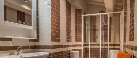 Baño con lavabo, inodoro y ducha.