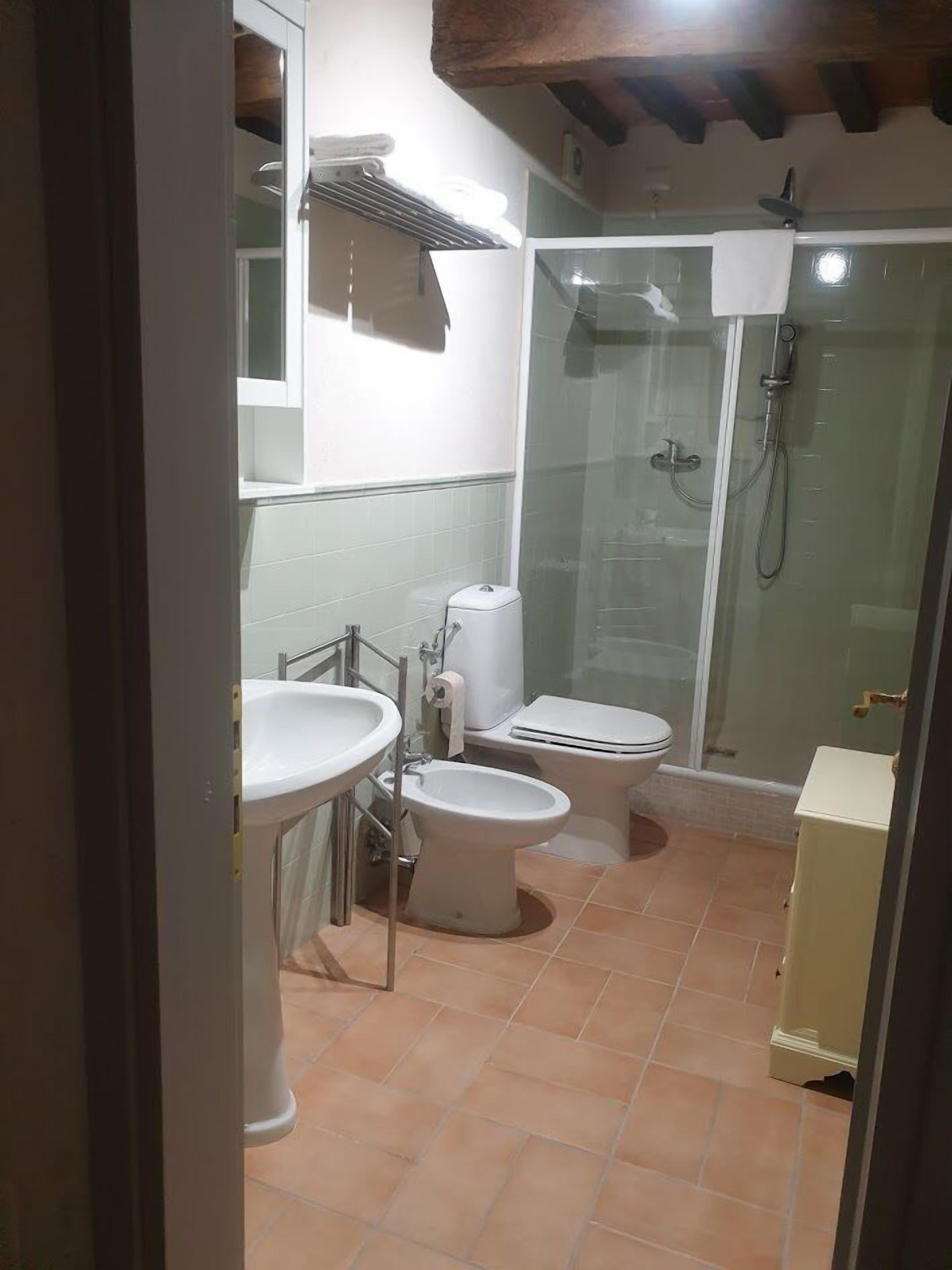 A bathroom with a toilet, bidet, and sink.