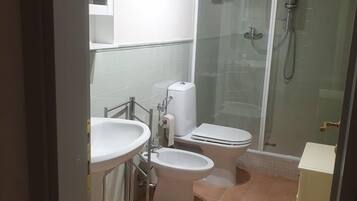 A bathroom with a toilet, bidet, and sink.