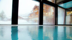 An indoor swimming pool with a view of a snowy mountain resort. - travelski home premium - Résidence Les Alpages de Val Cenis 4* (Val-Cenis)