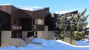 Um edifício com uma placa que diz 'Les Lys' em frente a uma paisagem coberta de neve.