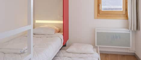 Quarto com beliche, janela e radiador.