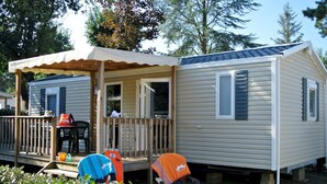 A mobile home with a porch, a small deck, and a covered seating area. - Camping Club Sunissim Le Trianon (Les Sables-d'Olonne)