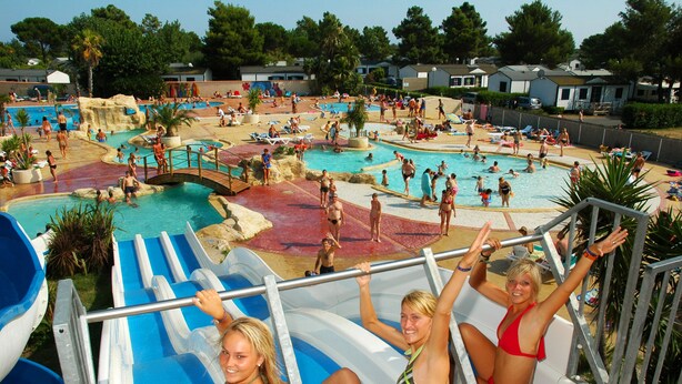 A water park with multiple pools and slides, surrounded by houses. - Camping Sunissim Le Domaine Les Mûriers (Vendres)