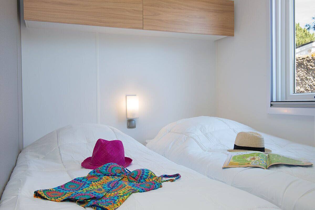 Ein Hotelzimmer mit zwei Betten, einer Wandleuchte und einem Fenster mit Blick.