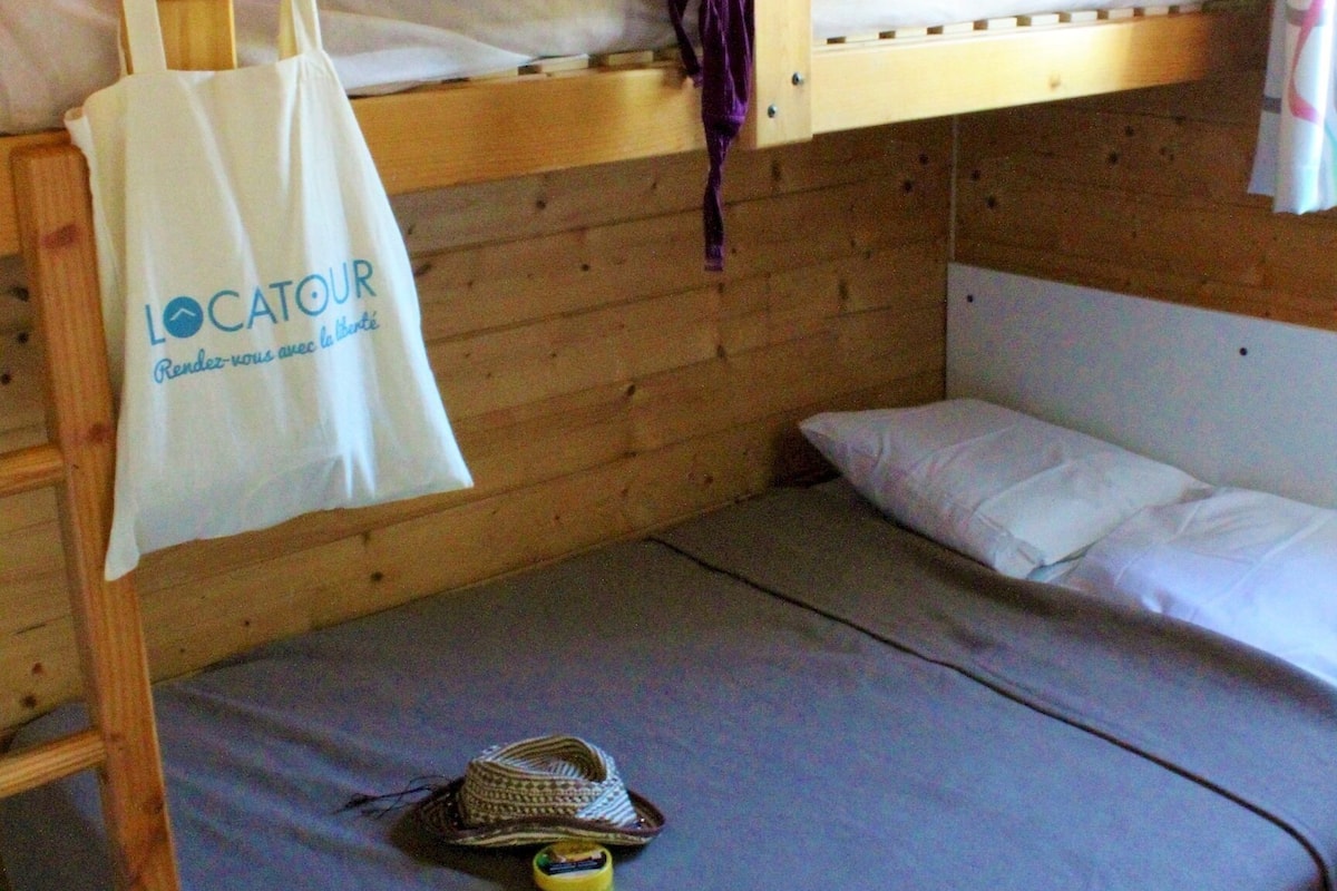 Ein Etagenbett mit einer weißen Tasche mit dem Aufdruck "LOCATOUR", die am Kopfteil hängt.