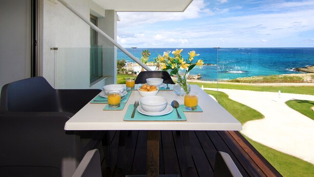 Una mesa dispuesta para el desayuno con vista al océano.
