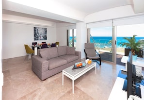 Relax in this spacious living room with a sofa, coffee table, and dining area, offering stunning ocean views.