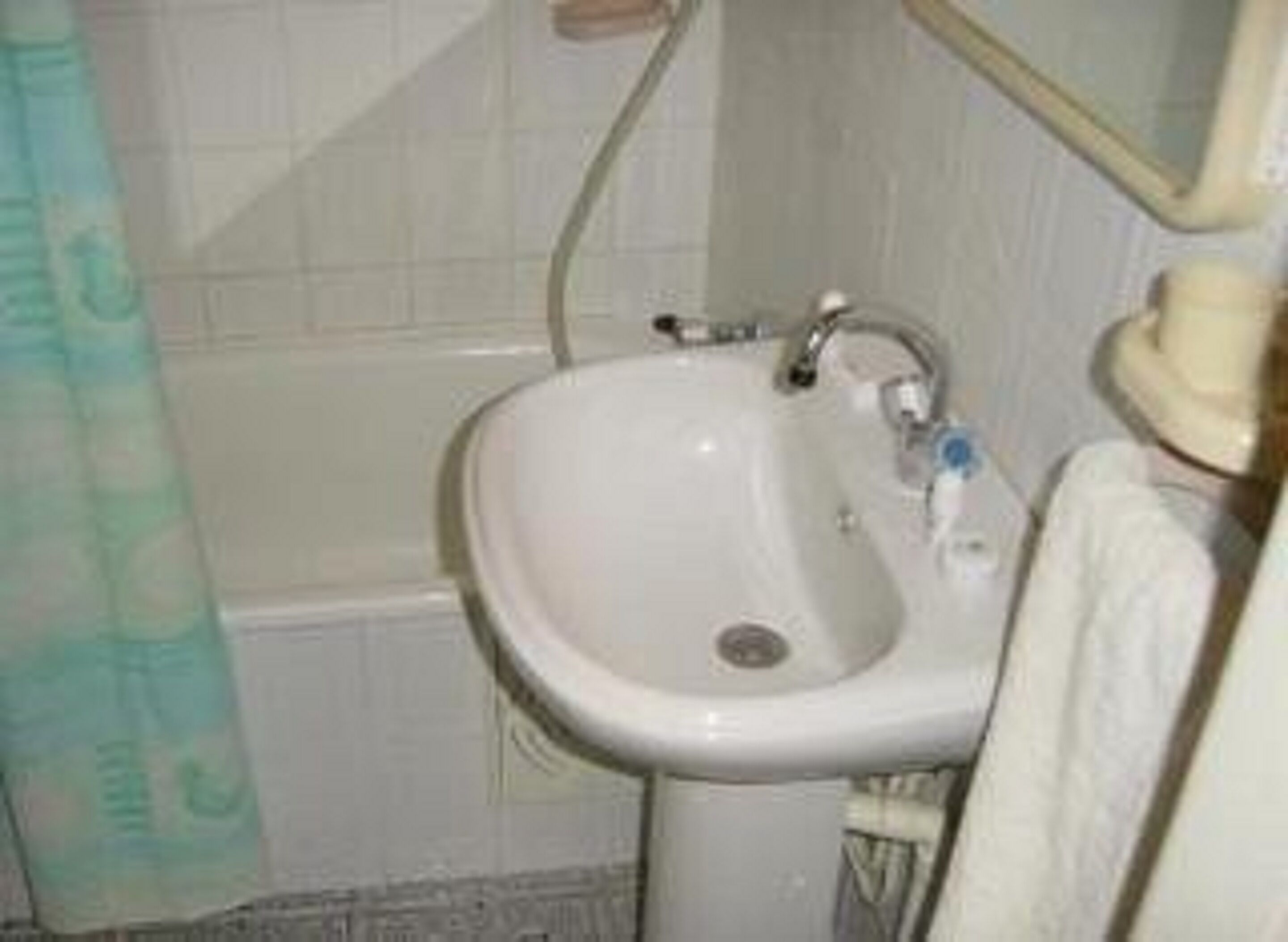 A bathroom with a white sink, a mirror, and a shower curtain.