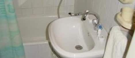 A bathroom with a white sink, a mirror, and a shower curtain.