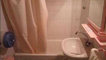 Ein kleines Badezimmer mit Badewanne, Waschbecken und Toilette.