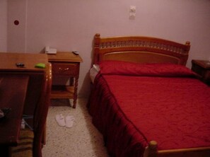 Une chambre à coucher avec un lit en bois, un bureau et une chaise.