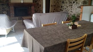 Un comedor con pared de piedra, chimenea y un cartel que dice 'BIENVENUE'.