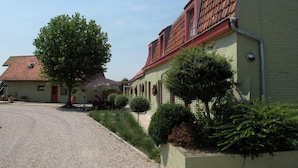 Una calle residencial con casas, un camino de grava y jardines bien cuidados.