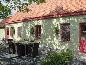A building with a red-tiled roof, a green exterior, and a sign indicating a B&B. - De Zoete Kers B&B (Dentergem)