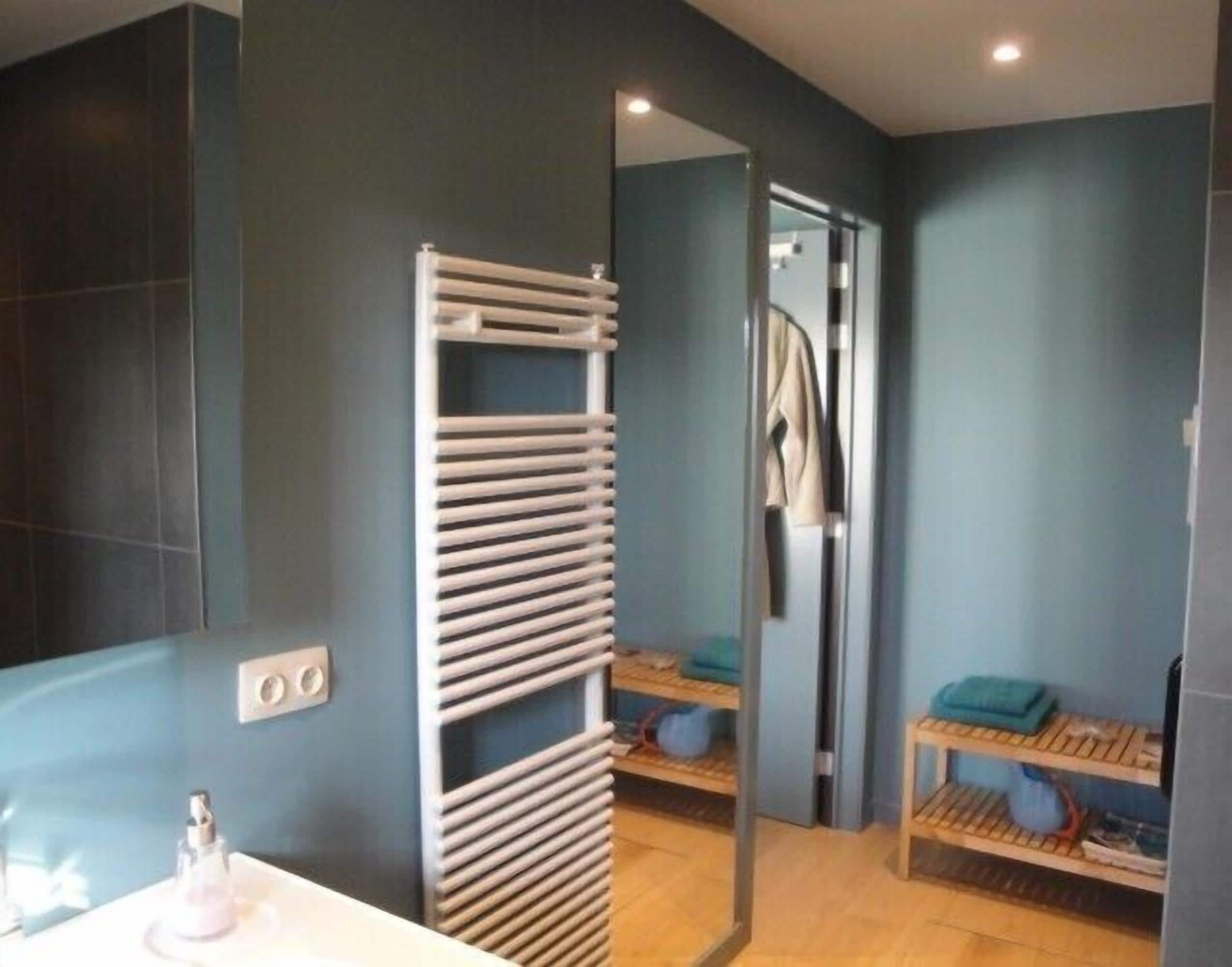 Un baño moderno con un perchero blanco, un espejo y una repisa con toallas.