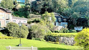 Un parque con un banco, un muro de piedra y edificios al fondo.