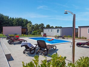 A pool area with lounge chairs and a small inflatable float. - Superior Mobile Homes Kastanija - Campsite (Novigrad)