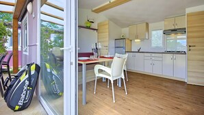 A modern kitchen with white cabinets, a wooden countertop, and a built-in stove. - Camping Adria Mobile Homes Park Umag (Brtonigla)