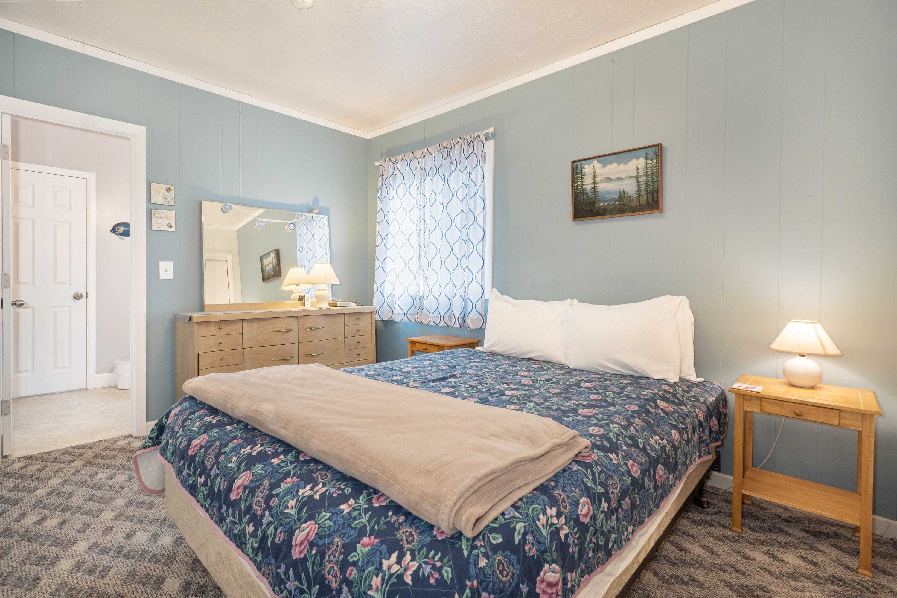 A bedroom with a bed, dresser, and nightstand.