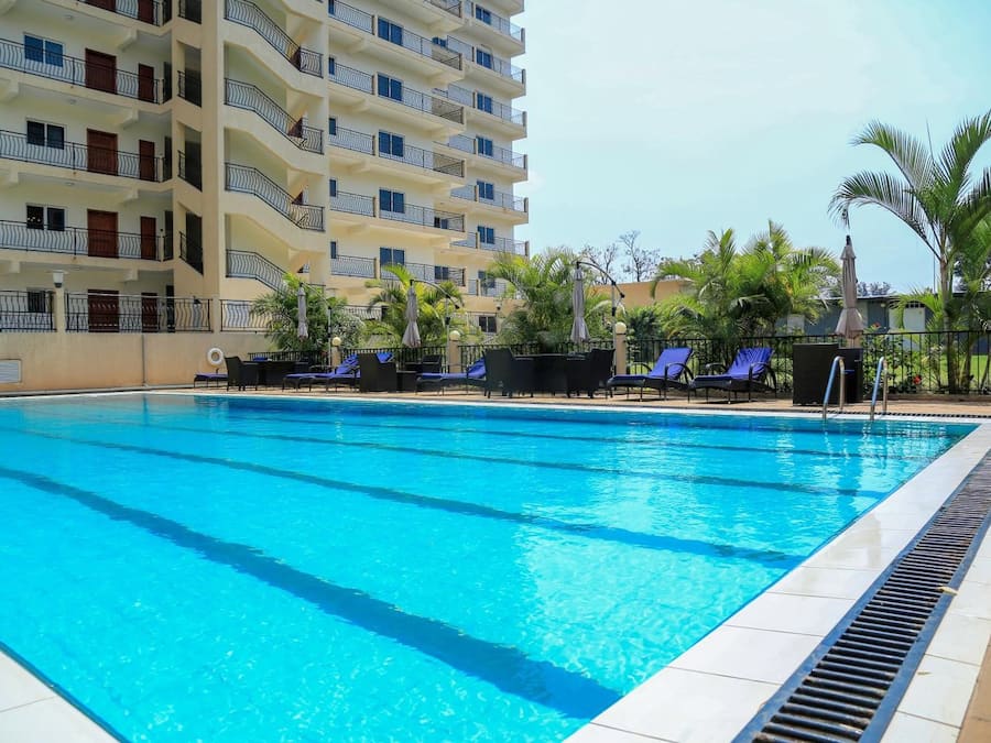 Una piscina al aire libre, sillones reclinables de piscina