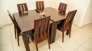 Una tavola rettangolare da pranzo con sei sedie in legno.