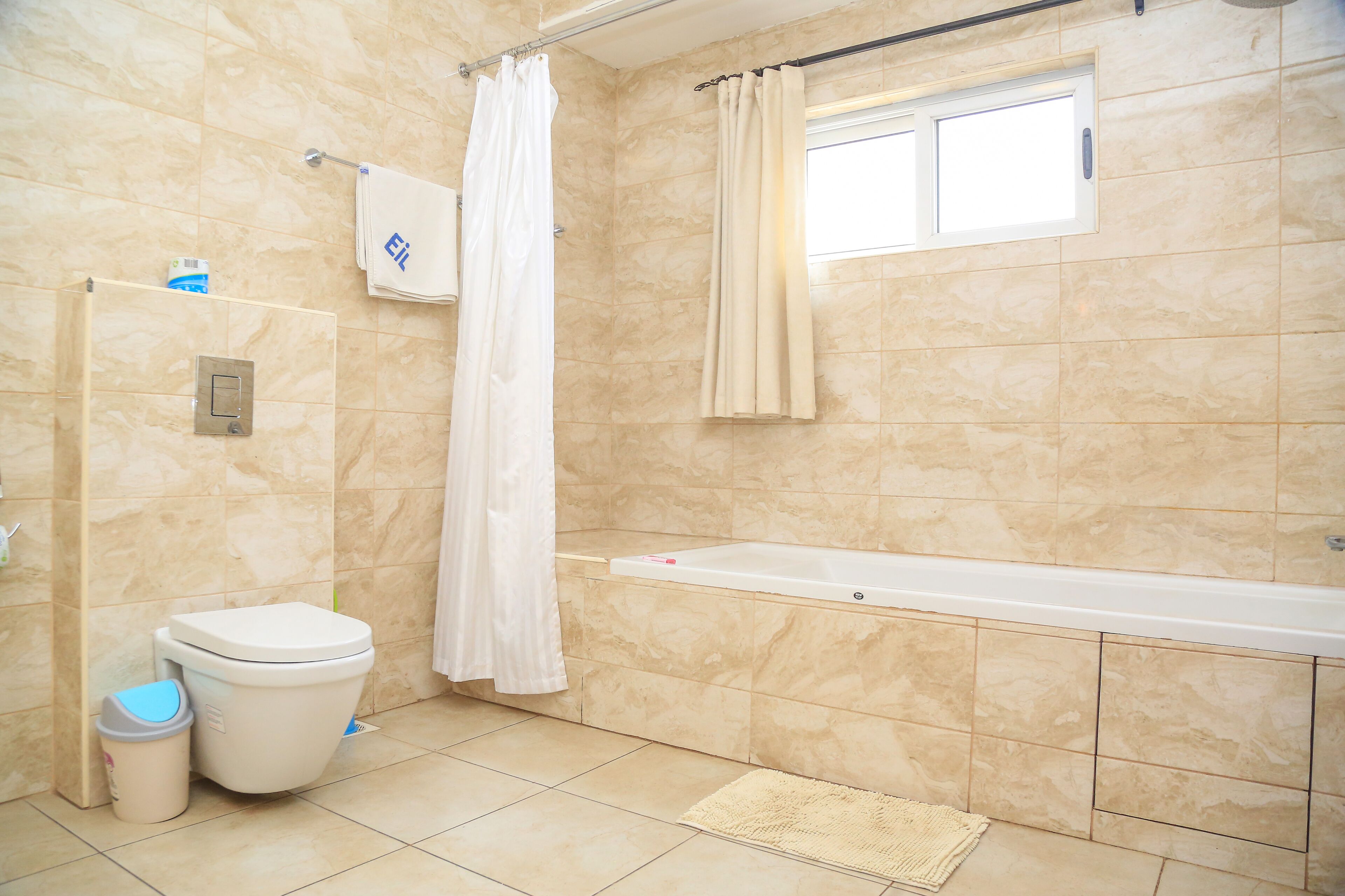 A bathroom with a bathtub, toilet, and shower curtain.