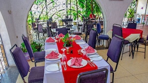 Un comedor con una mesa larga preparada para seis personas, rodeada de sillas.