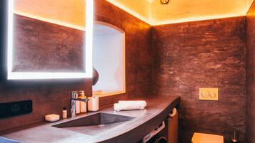 A compact bathroom with a built-in sink, mirror, and toilet.