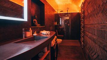 Ein kleines, modernes Badezimmer mit großem Spiegel, Waschbecken und Toilette.