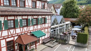 A traditional half-timbered building with a café patio and outdoor seating.